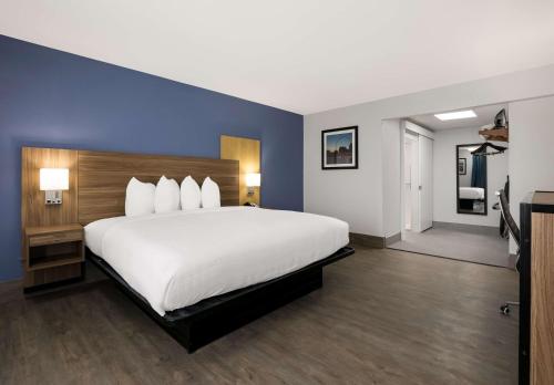 a large bedroom with a large white bed with blue walls at SureStay Plus by Best Western Pigeon Forge in Pigeon Forge