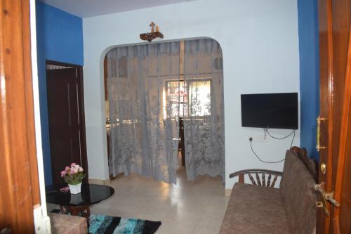 a living room with a curtain and a television at Casa de Aaron in Colva