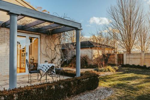 Un patio con una mesa y sillas en un patio. en Alderwood Homestead - Heart Of The Highlands, en Glenquarry