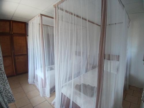 Habitación con cortinas blancas y ventana en Casa Nova, Barra, en Miramar