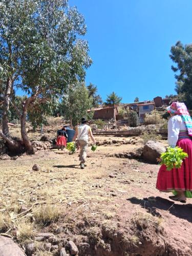 a man and a woman walking in a field at Casa de Alejandra llachon in Llachon