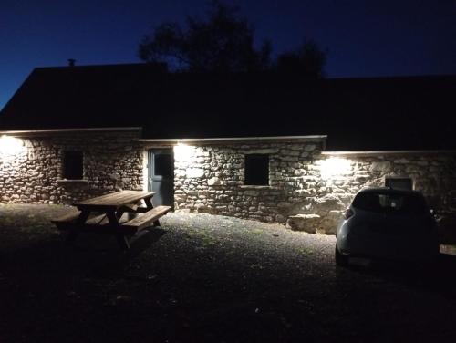 a bench in front of a stone building at night at Aghavannagh Mountain Lodge in Aghavannagh