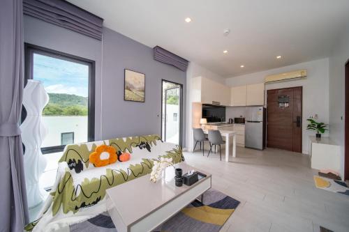 a living room with a couch and a kitchen at 九雅集 The Nine Refined Retreats in Rawai Beach