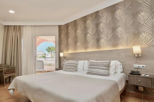 a bedroom with a large white bed with two pillows at Hotel Puerto Palace in Puerto de la Cruz