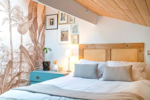 a bedroom with a large bed with a blue nightstand at Une escale sur l'océan in Ciboure