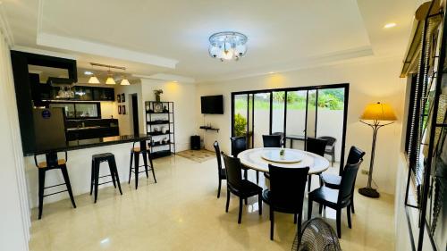 a living room with a table and chairs and a kitchen at Soleil Pines Place Tagaytay in Tagaytay