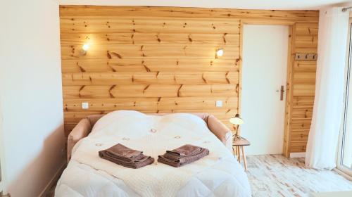 a bed in a room with a wooden wall at Maison bien être avec sauna - Gîte les 4 saisons - Lac de chalain in Marigny