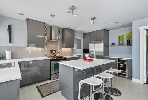 a kitchen with gray cabinets and white counter tops at Modern Upper Level Duplex DT Vancouver in Vancouver