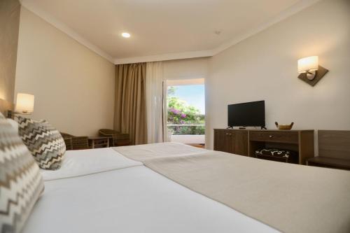 a hotel room with a large bed and a television at Hotel Puerto Palace in Puerto de la Cruz