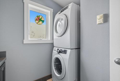 a kitchen with a washing machine and a window at Modern Upper Level Duplex DT Vancouver in Vancouver