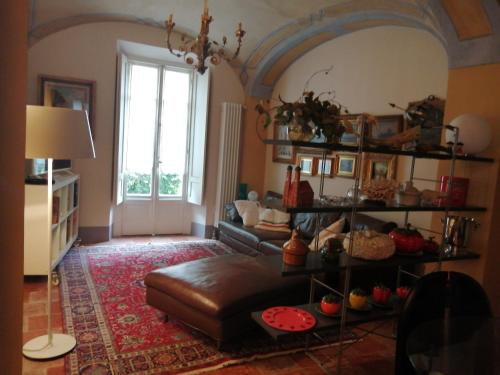 a living room with a leather couch and a window at Le Melusine Appartamento Grazia in Vercelli