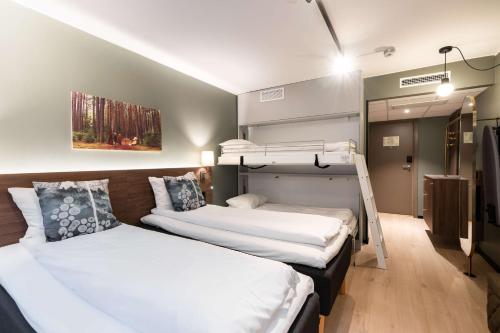 two beds in a room with two bunk beds at Scandic Hell in Hell