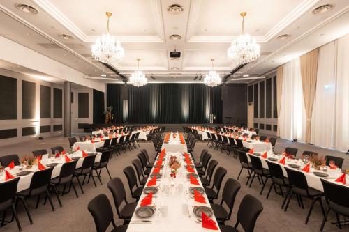 a banquet hall with tables and chairs and chandeliers at Scandic Hell in Hell