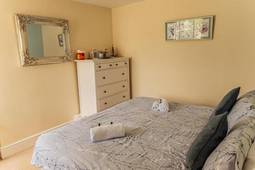 a bedroom with a bed with a dresser and a mirror at The Wayfarer Inn in Instow