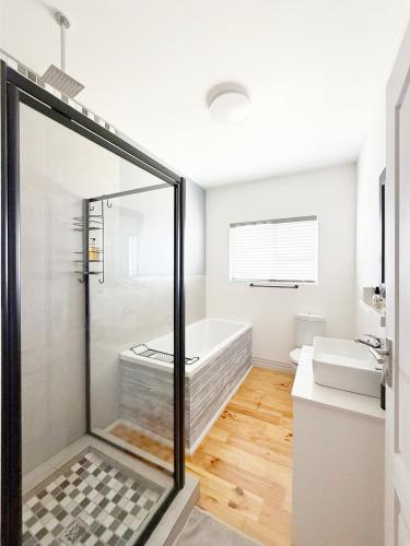 a bathroom with a shower and a bath tub at The Bucket List Guest House in Bredasdorp
