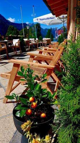 a group of wooden tables and benches with oranges at Alpenhotel Edelweiss in Maurach