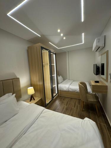 a hotel room with two beds and a desk at Rotana Pyramids View in Cairo