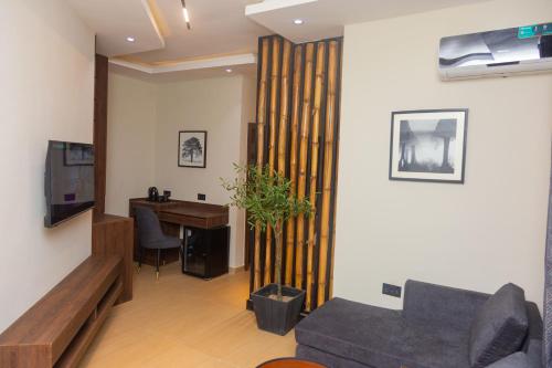 a living room with a couch and a table and a desk at Grayville Hotels and Bistro in Akure