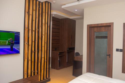 a living room with a tv on a wall at Grayville Hotels and Bistro in Akure