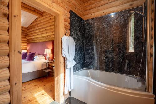a bathroom with a tub and a bed in a room at Alborada in Constable Burton