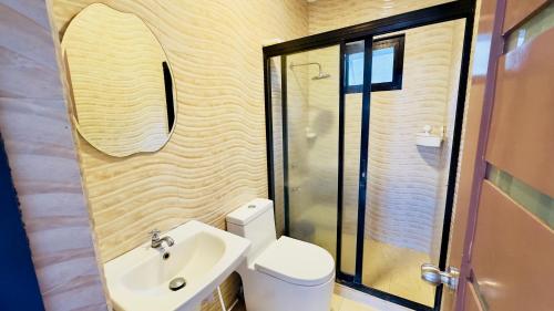 a bathroom with a toilet and a sink and a shower at Soleil Pines Place Tagaytay in Tagaytay