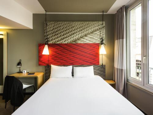 a bedroom with a large bed and a desk and a window at ibis Bordeaux Centre Gare Saint Jean Euratlantique in Bordeaux