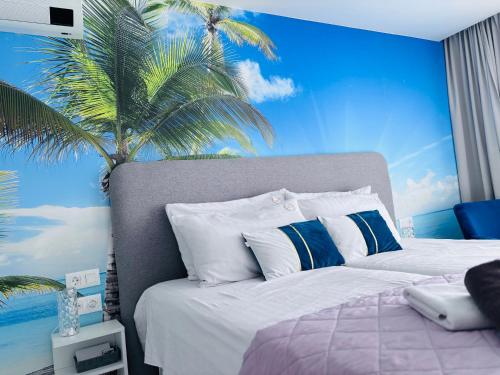a bedroom with a bed with a palm tree mural at Blue Ocean Costa Adeje 504 in Playa de las Americas