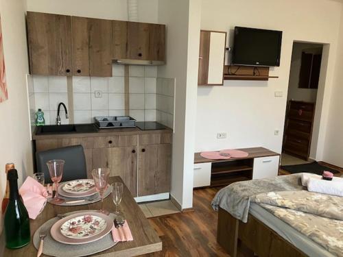 a kitchen with a table with plates and glasses on it at Apartments-rooms Vogrinec in Ptuj