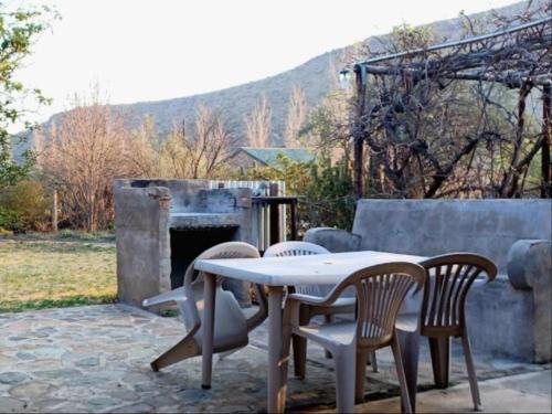a table and chairs on a patio with a fireplace at Starry Nights Guest House in Nieu-Bethesda