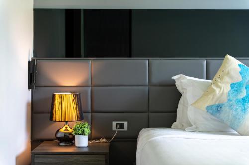 a bedroom with a bed and a lamp on a table at 九雅集 The Nine Refined Retreats in Rawai Beach