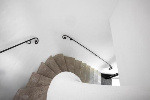 a spiral staircase in a building with two metal rails at Le Clos Du Buis in Bonnieux