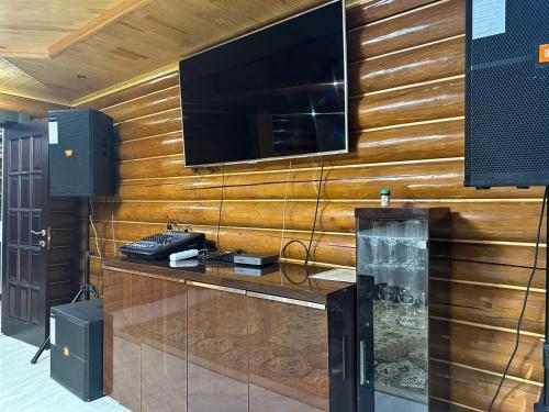 a television on a wooden wall in a room at Дом СКАЗКА in Astana