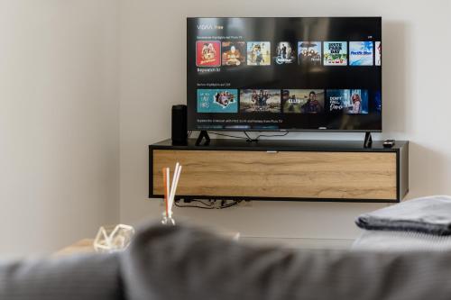 Televisyen dan/atau pusat hiburan di Kleeoase - Luxus Apartment- Jacuzzi - Dachterrasse - Kochinsel - See in 10 min