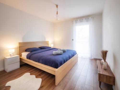 a bedroom with a large bed with blue sheets at T3 68m2 Garage Terrasse Gare aux portes de Genève in Saint-Julien-en-Genevois