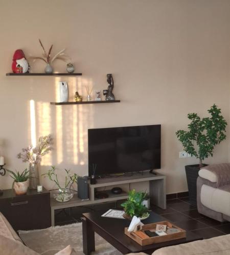 a living room with a flat screen tv on a wall at B&B Apartment in Shkodër