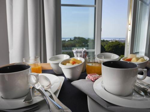 a table with cups and bowls of fruit and juice at Hotel Mercure Brest Centre Les Voyageurs in Brest