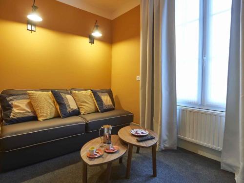 a living room with a couch and two tables at Hotel Mercure Brest Centre Les Voyageurs in Brest