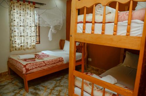 a bedroom with two bunk beds and a window at Gorilla African Guest House in Entebbe