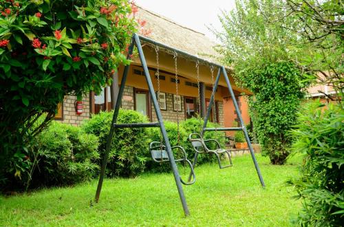 a swing set in the yard of a house at Gorilla African Guest House in Entebbe