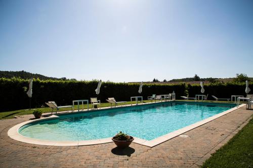a large swimming pool with chairs in a yard at Casa VolaTerrA in Volterra