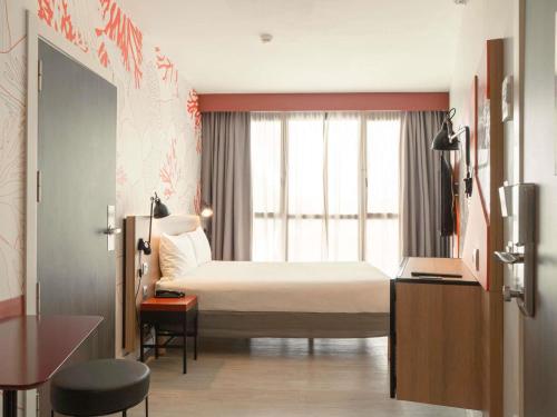 a hotel room with a bed and a window at ibis Styles Barcelona City Bogatell in Barcelona