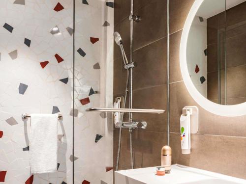 a bathroom with a shower with a sink and a mirror at ibis Styles Barcelona City Bogatell in Barcelona