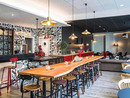 a long wooden table in a restaurant with stools at ibis Styles Barcelona City Bogatell in Barcelona