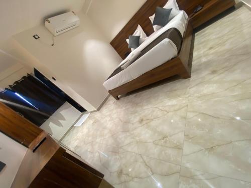 a bedroom with a bed with a marble floor at Aatithya Residency in Alandi
