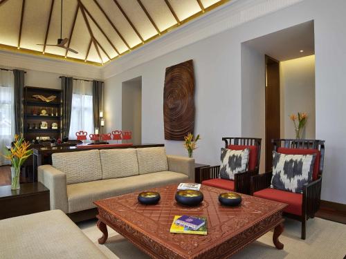 a living room with a couch and a table at Pullman Luang Prabang in Luang Prabang