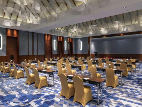 a conference room with tables and chairs and a projection screen at Pullman Luang Prabang in Luang Prabang