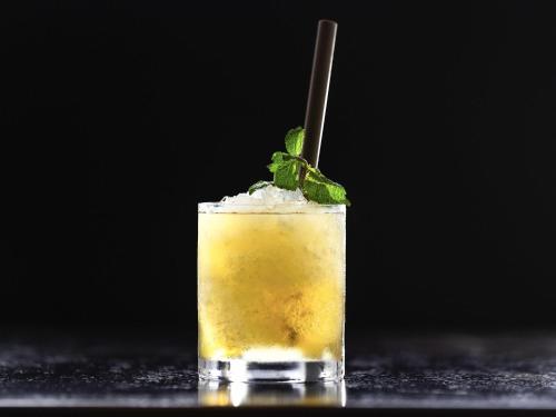 a drink sitting on a table with a spoon in it at Pullman Luang Prabang in Luang Prabang
