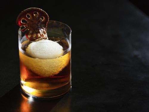 a glass of alcohol with a lemon slice on top at Pullman Luang Prabang in Luang Prabang
