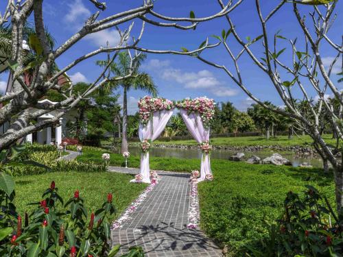 a wedding arch in the middle of a garden at Pullman Luang Prabang in Luang Prabang
