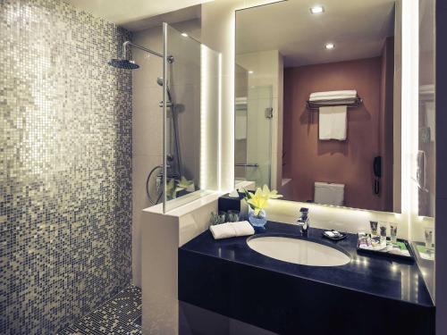 a bathroom with a sink and a mirror at Mercure Yangon Kaba Aye in Yangon